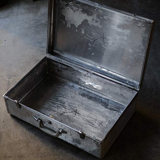 A well-worn aluminum trunk