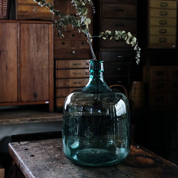 A small aqua blue demijohn bottle