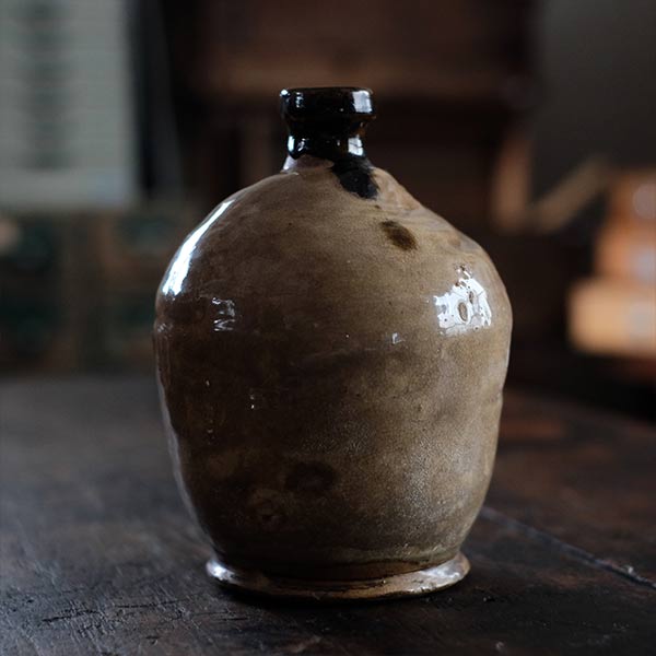 A slightly bent sake bottle