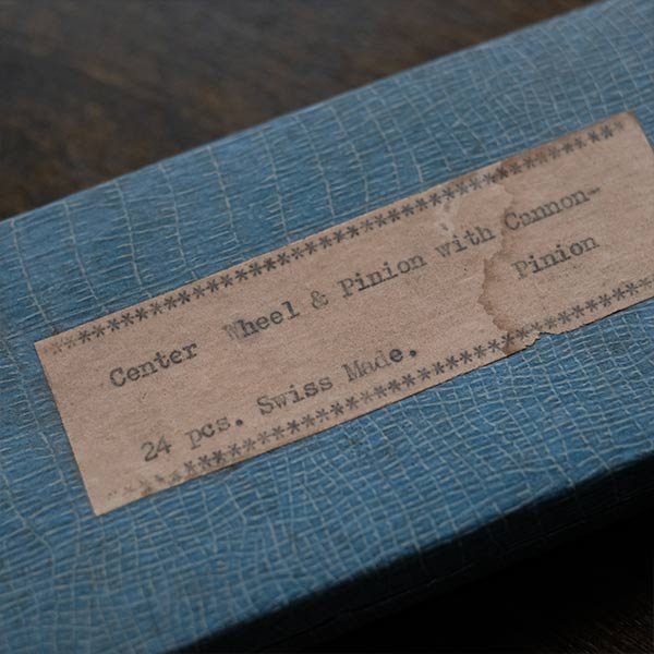 A set of small jars containing mechanical watch parts