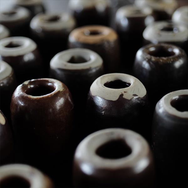 Ceramic sinkers attached to fishing nets