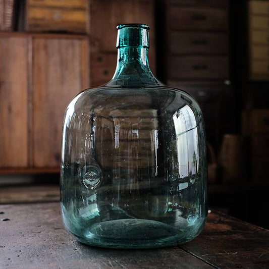 A small aqua blue demijohn bottle