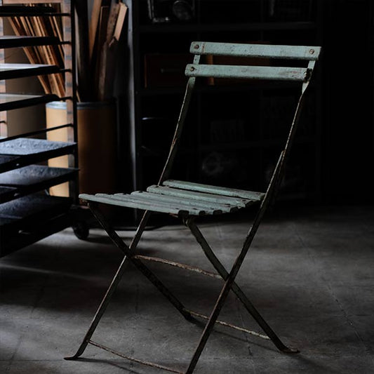 Rusty iron-legged folding chair