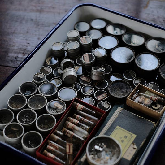 Cans and bottles containing watch parts (85 cans, 85 bottles)